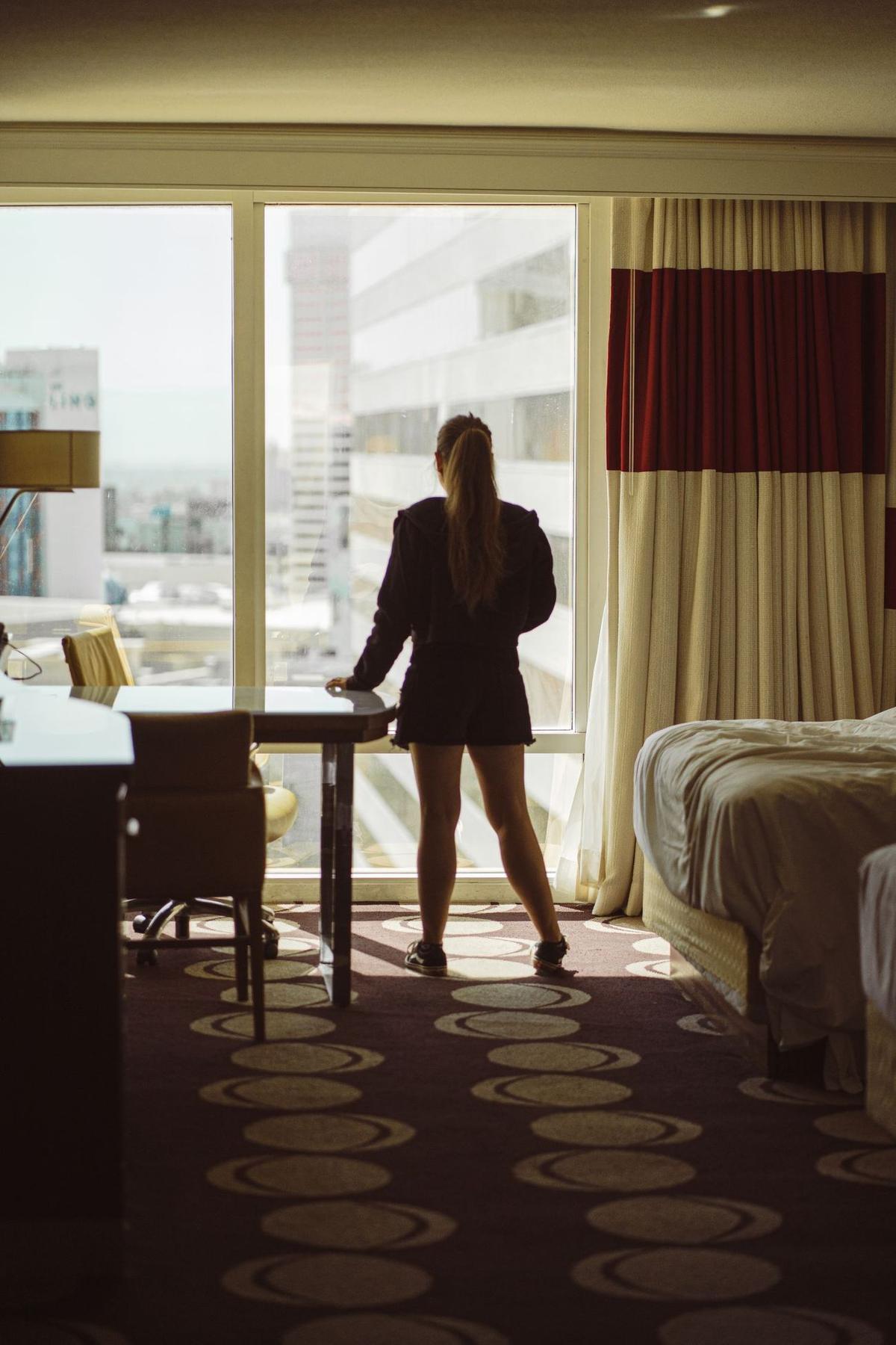 Una huésped mirando la ciudad desde su habitación